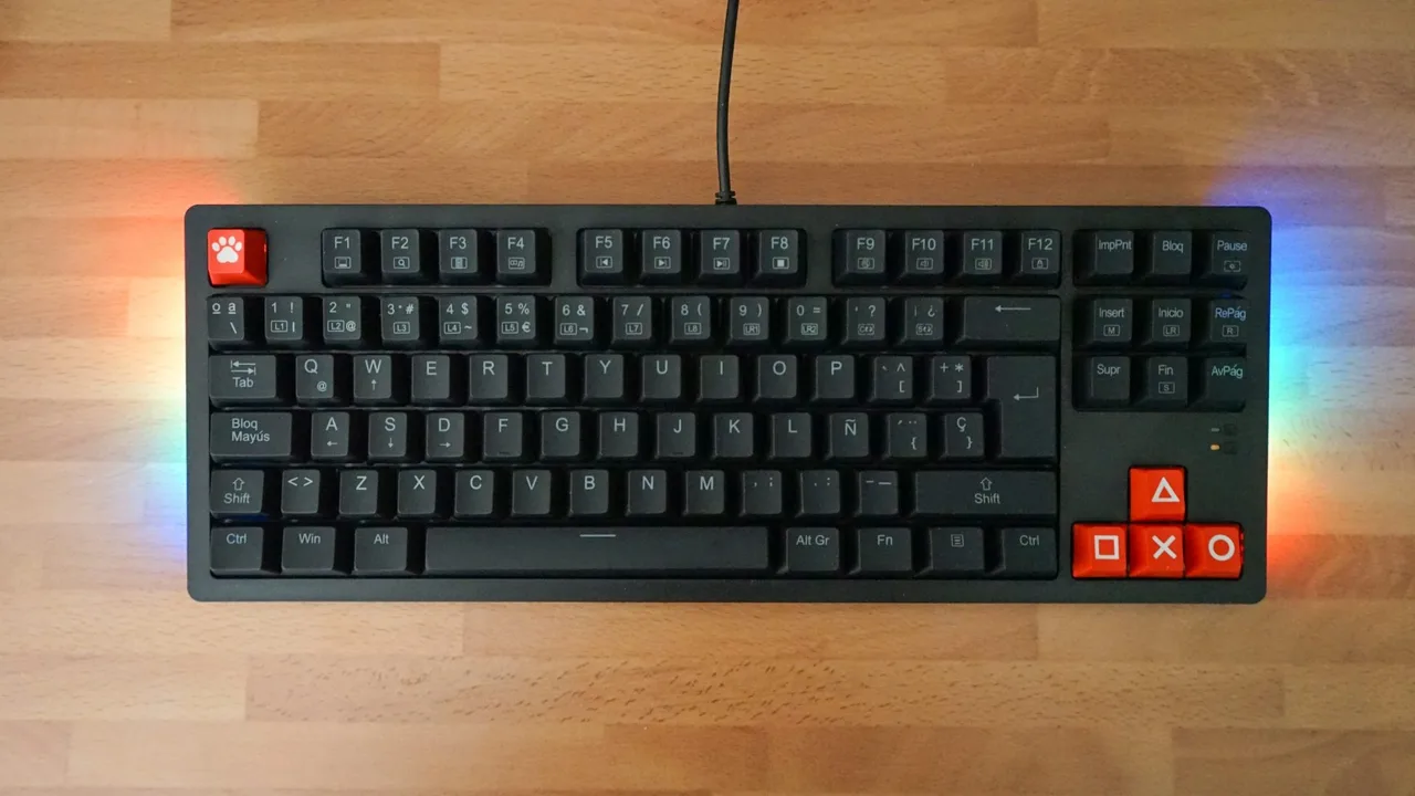Tenkeyless gaming keyboard with RGB underglow on a light wooden desk